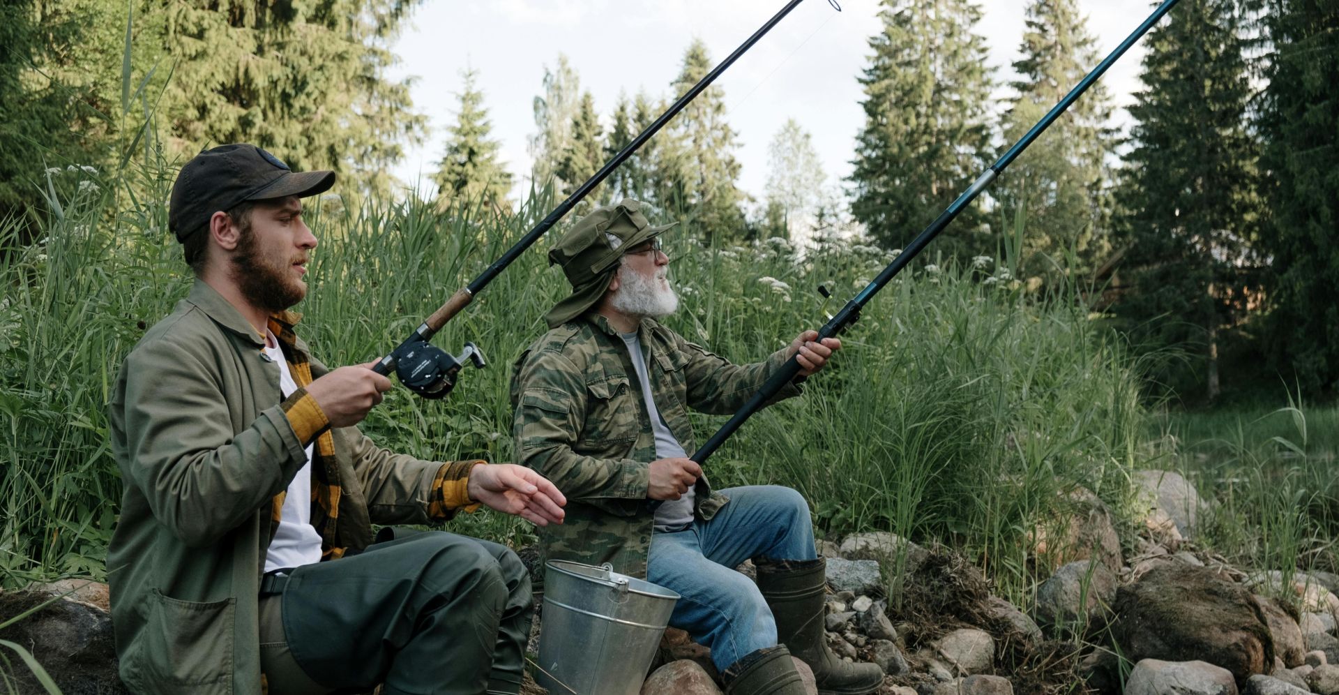 Two men enjoying a peaceful fishing trip by a scenic lake in summer.